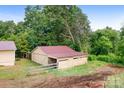 Exterior view of a wooden outbuilding and grass lawn surrounded by trees at 4026 Biggerstaff Rd, Maiden, NC 28650