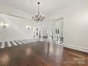 Open living area with hardwood floors, chandelier, and elegant white columns at 4300 Cameron Oaks Dr, Charlotte, NC 28211