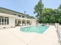 A luxurious backyard features a sparkling pool, a hot tub, and ample seating for entertaining at 4300 Cameron Oaks Dr, Charlotte, NC 28211