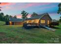 Backyard view features a deck with a pergola, a brick house and a large lawn at 5916 Cashion Rd, Huntersville, NC 28078