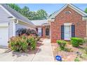Inviting home entrance with a decorative wreath, manicured shrubs, and a pathway leading to the front door at 7033 Spandril Ln, Charlotte, NC 28215