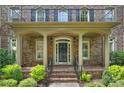 Inviting front porch with classic columns, brick steps, and manicured landscaping at 7319 Stonehaven Dr, Waxhaw, NC 28173