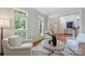 Bright living room featuring white armchairs and large windows with custom shutters at 7319 Stonehaven Dr, Waxhaw, NC 28173