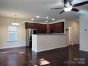 Open-concept layout connects the kitchen, showcasing modern appliances and wood flooring at 7323 Jane Parks Way, Charlotte, NC 28217