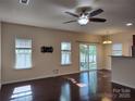 Bright living room boasts wood floors, neutral walls, ceiling fan and sliding door access at 7323 Jane Parks Way, Charlotte, NC 28217