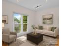 Cozy staged living room with neutral decor, large window, and comfortable seating at 765 Portpatrick Pl, Fort Mill, SC 29708