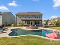 Beautiful backyard with a large in-ground pool, stone fire pit, patio with pergola and fenced yard at 1001 Hampton Grove Rd, Waxhaw, NC 28173
