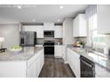 Contemporary kitchen with white cabinets, stainless steel appliances, granite countertops, and hardwood floors at 10116 Florentine Way, Charlotte, NC 28214
