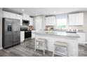 Modern kitchen featuring white cabinetry, stainless steel appliances, and a breakfast bar with stylish seating at 10116 Florentine Way, Charlotte, NC 28214