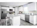 Bright kitchen with white cabinets, stainless steel appliances, granite countertops, and hardwood floors at 10116 Florentine Way, Charlotte, NC 28214