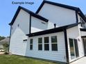 A bright modern home shows a clean design with black gutters, white siding, and lots of large windows at 11009 Tyler Brook Ln # Oak0043, Mint Hill, NC 28227