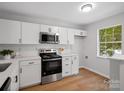 Modern kitchen featuring white cabinets, stainless steel appliances, and a bright window at 1231 Maple Shade Ln, Charlotte, NC 28270