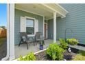 Inviting front porch with seating, vibrant plants, and a charming view at 133 Aspire Cir, Wingate, NC 28174