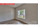 Bedroom featuring wood-look floors and a window overlooking the backyard at 1369 Secrest Commons Dr, Monroe, NC 28112