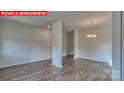 Open-concept living room featuring wood-look floors and recessed lighting at 1369 Secrest Commons Dr, Monroe, NC 28112