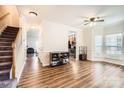 Open living area featuring hardwood floors, a ceiling fan, and large windows at 13820 Cypress Woods Dr, Huntersville, NC 28078