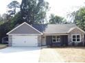 Inviting single-story home boasts a gray exterior, stone details, and a convenient two-car garage at 1802 Cooper Ave, Kannapolis, NC 28081
