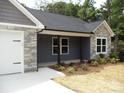 View of the home's facade showcases stone detailing, fresh landscaping, and an attached garage at 1802 Cooper Ave, Kannapolis, NC 28081