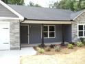 The home features fresh landscaping, stone accents, and a covered porch at 1802 Cooper Ave, Kannapolis, NC 28081