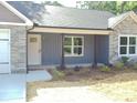 Close-up of the front of a gray single-story home with a gray door and a stone facade at 1802 Cooper Ave, Kannapolis, NC 28081