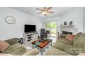 Cozy living room with fireplace, ceiling fan, plush seating, and sliding door to a balcony at 18741 Nautical Dr # 205, Cornelius, NC 28031