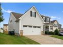 Side view of a two-story home featuring an attached two-car garage and a well-kept lawn at 204 Fesperman Cir, Troutman, NC 28166