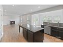 Open-concept kitchen with an island, stainless steel appliances, and a view of the living area at 207 Welcombe St, Mooresville, NC 28115