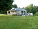 Stone house with a covered porch, mature trees, and a spacious yard at 209 14Th Se Ave, Hickory, NC 28602