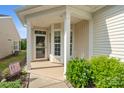 Inviting front porch with decorative columns, a screen door, and landscaping at 23117 Whimbrel Cir, Fort Mill, SC 29707
