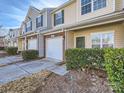 View of townhouses each featuring a one car garage, brick, and beautiful front landscaping at 463 Delta Dr, Fort Mill, SC 29715