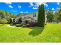 Attractive townhouse featuring a covered entrance, lush landscaping, and a sprawling green lawn at 49009 Dockside Ln # D, Albemarle, NC 28001