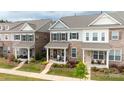 Desirable townhomes with covered front porches, colorful flower beds, and lush green lawns at 5440 Kinsbridge Dr, Charlotte, NC 28227