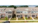 Attractive townhomes featuring manicured lawns, colorful flowers, and inviting covered front porches at 5440 Kinsbridge Dr, Charlotte, NC 28227