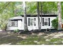Charming house with lush greenery, featuring black shutters, a stone bench, and meticulously maintained landscaping at 6128 Coatbridge Ln, Charlotte, NC 28212