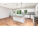 New kitchen boasts white cabinets, a central island with marble countertop and wood floors at 627 West Main Ext, Lincolnton, NC 28092