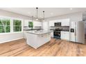 Bright kitchen features an island with marble countertops, stainless steel appliances, and wood floors at 627 West Main Ext, Lincolnton, NC 28092