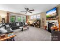Spacious living room features a ceiling fan, a fireplace, and large windows at 708 Ardent Trl, Belmont, NC 28012