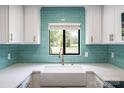 Bright kitchen boasts a white sink, counters and turquoise backsplash at 712 Mallard Head Ln, Mooresville, NC 28117