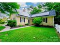 Inviting two-story home with solar panels, black shutters, mature landscaping, and a lush green lawn at 7521 Surreywood Pl, Charlotte, NC 28270