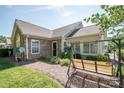 Exterior view of a well-maintained home with an inviting outdoor seating area and manicured greenery at 8183 Sultana Cir, Charlotte, NC 28227