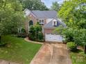 Well-maintained brick home with lush greenery, two-car garage, and a spacious driveway at 8219 Beardsley Dr, Charlotte, NC 28269
