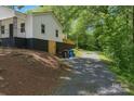 Exterior side view of home on an inclining lot showing the long gravel driveway at 905 Gantt St, Kings Mountain, NC 28086