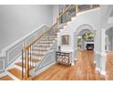 Elegant foyer with hardwood floors, staircase with wrought iron spindles, and decorative wall paneling at 9112 Butterfly Ct, Gastonia, NC 28056