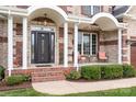 Charming front porch with brick steps, white columns, and seating area, adding to the home's curb appeal at 9112 Butterfly Ct, Gastonia, NC 28056