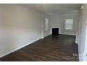 Spacious living room features dark wood flooring, a cozy fireplace, and ample natural light at 9730 Tea Garden Dr, Gastonia, NC 28056