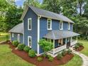 Lovely two-story home featuring a covered front porch and lush landscaping at 9929 Kerns Rd, Huntersville, NC 28078