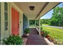 Inviting front porch with decorative plants, leading to a brightly colored front door at 9929 Kerns Rd, Huntersville, NC 28078