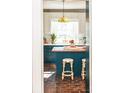 Charming kitchen featuring a center island with seating, a brick floor, and ample natural light at 9929 Kerns Rd, Huntersville, NC 28078