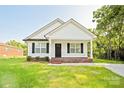 Charming single-story home with white siding, black shutters, and a well-manicured front lawn at 1028 Gibson St, Albemarle, NC 28001