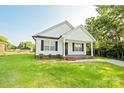 Beautifully landscaped front yard of a single-story home with white siding and black shutters at 1028 Gibson St, Albemarle, NC 28001